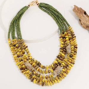 Detail of bohemian multilayer beaded necklace featuring green resin tubes and golden OT clasp