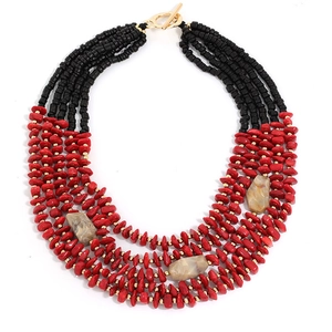 Detail of layered bohemian beaded necklace with red and black beads and gold toggle clasp