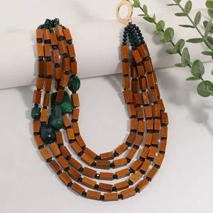 Bohemian multi-layer necklace with brown wood beads and green resin accents on a white stand
