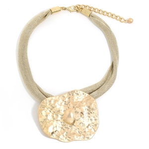 Macro shot of gold mesh chain and textured hammered pendant with amber stone