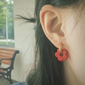 Red flower earrings with gold hoop worn by a woman for a sweet, refreshing style