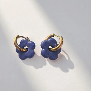 Detail view of lavender resin flower petal earrings with a polished gold metal hoop
