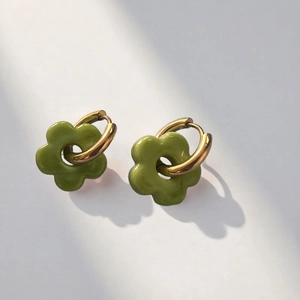 Detail view of grass green glass flower petal earrings with polished gold metal hoops