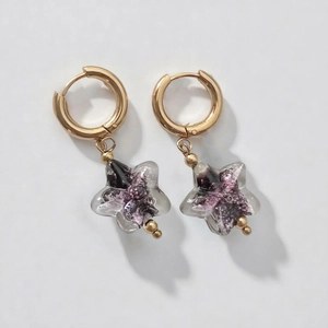 Detail showing handmade gold star earrings with sparkling purple and silver sequins