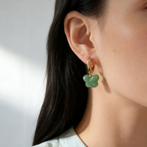Elegant 18K gold plated butterfly drop earrings with green jade stone charms on a model