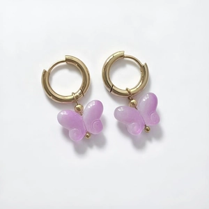 Detail of 18K gold-plated butterfly earrings with purple gradient resin charms and hoop clasp