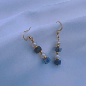 Close-up of vintage beaded long tassel earrings with pearls and blue marble stone beads