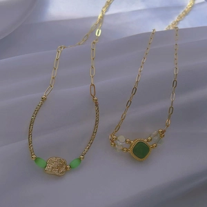 Gold pendant necklace set with green cat-eye stones and irregular textured gold charms