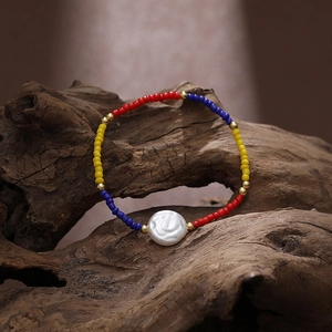 Bohemian colorful seed bead and pearl stretch bracelet displayed on natural wood