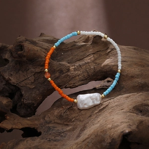 Detail of colorful seed beads and large baroque pearl on bohemian stretch bracelet