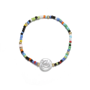 Close-up of bohemian beaded bracelet with multi-color beads and a large baroque pearl