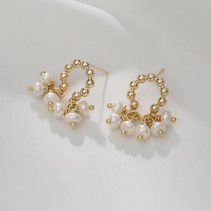 14K gold plated C-hoop earrings with baroque pearl tassels on white fabric background