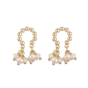 Macro shot of 14K gold beaded C-ring earrings with white Baroque pearl tassels