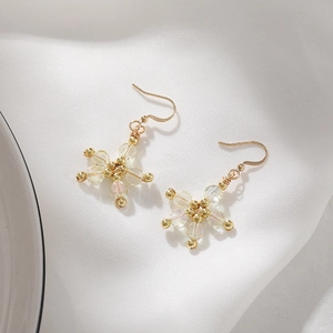 Close-up of pink cat eye stone flower drop earrings with golden wire wrapped beads