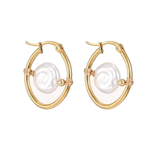 Detail view of handmade gold wire-wrapped pearl earrings with oval metal frames