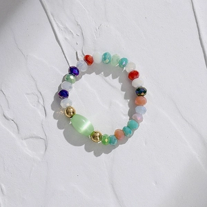 Vue détaillée d'une bague élastique en perles colorées à facettes avec pierre œil de chat