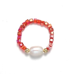 Gros plan sur les perles de cristal rouge et la perle centrale d'une bague élastique