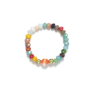 Vue macro d'une bague élastique avec pierre œil de chat colorée et perles à facettes