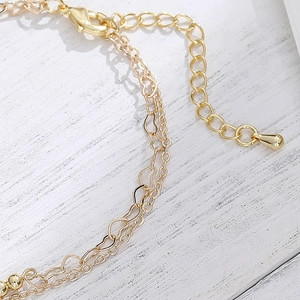 Double-layer 14K gold minimalist chain bracelet featuring hollow heart and coin pendant links