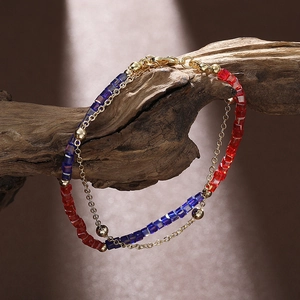Double-layered beaded bracelet with blue and red crystals on a natural wood stand