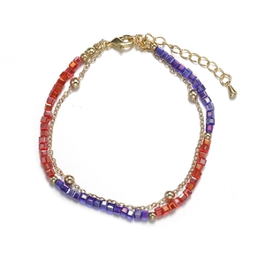 Detail of double-layer bracelet with red and purple crystal beads and gold chain