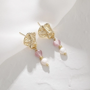 Detail of 14K gold irregular earrings with pink cat eye stone and white pearl