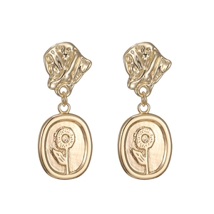 Vintage gold sunflower earrings with embossed metal relief on a minimalist white background