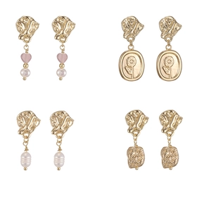 Detail view of four 14K gold pearl earrings with heart charms and floral relief
