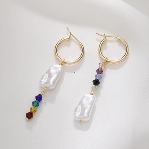 Detailed macro view of asymmetric baroque pearl earrings with colorful crystal beads