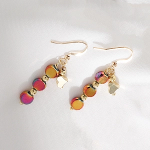 Gold dangle earrings with colorful iridescent beads and heart charm on white silk