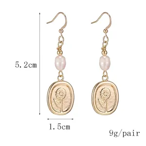 Golden drop earrings with freshwater pearl and embossed sunflower oval charms