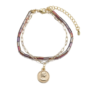 Bohemian layered bracelet featuring colorful metallic beads and a vintage coin pendant