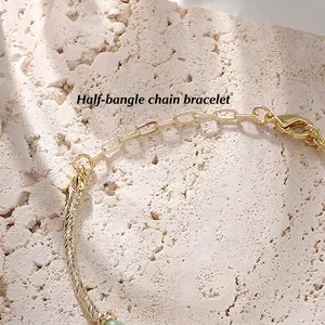Gold semi-bangle bracelet with hammered texture and green cat-eye stone bead detail