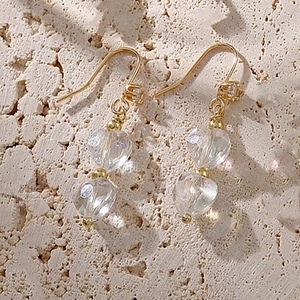 Boucles d'oreilles vintage cœur en or avec zircons et perles de cristal sur fond de pierre