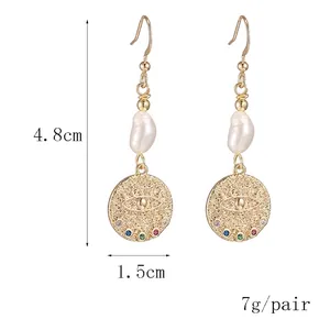French 14k gold freshwater pearl earrings with diamond-encrusted evil eye charm