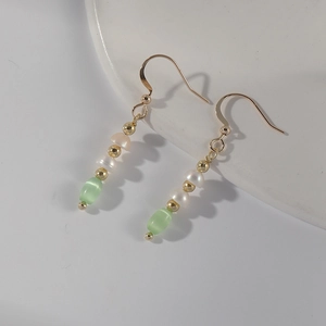 Detail of 14k gold-plated French retro earrings with green natural stone and pearls