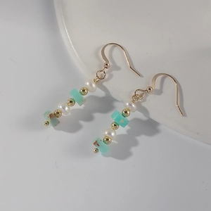 French vintage earrings with freshwater pearls and blue stone on a white ceramic tray