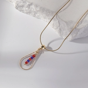 Gold stainless steel necklace with water-drop pendant and colored beads on white stone