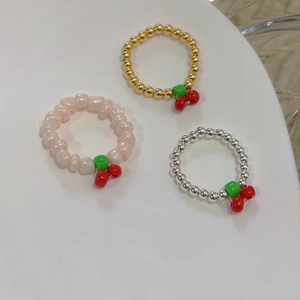 Set di tre anelli con perline a ciliegia con perle rosa e fasce in metallo dorate