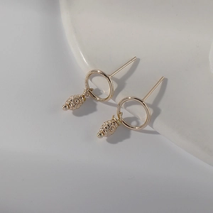 14K gold plated hoop earrings with vintage pine cone pendants on minimalist background