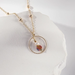 14K gold plated necklace with freshwater pearl and iridescent bead on textured stone