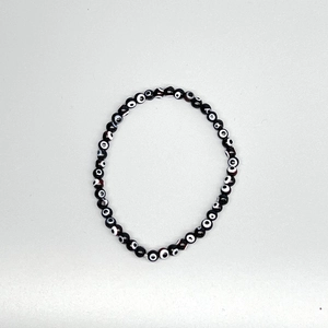 Detailed view of elastic evil eye beaded bracelet with blue glass resin charms