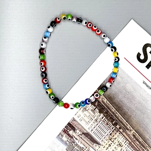 Detailed view of colorful evil eye beaded elastic bracelet with glass eye charms