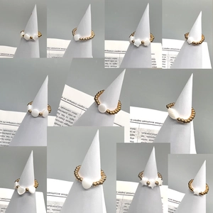 Stackable 18K gold stainless steel beaded rings with assorted white shell charms