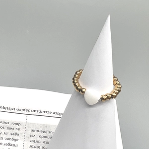 Detail of 18K gold stainless steel beaded ring with a white heart shell inlay