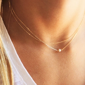 Double-layered 14K gold-plated titanium necklace featuring a delicate freshwater pearl charm