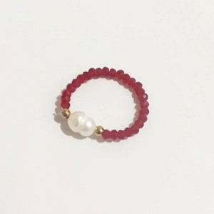 Detail of handmade elastic ring featuring red crystal beads and a white freshwater pearl