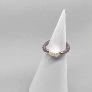 Detailed shot of handmade elastic ring with baroque pearl and purple crystal beads