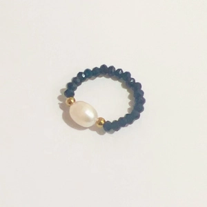 Detail of beaded ring with dark blue faceted beads and a white freshwater pearl