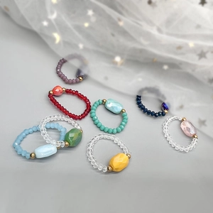 Colorful crystal beaded elastic rings with central gemstone in various vibrant shades